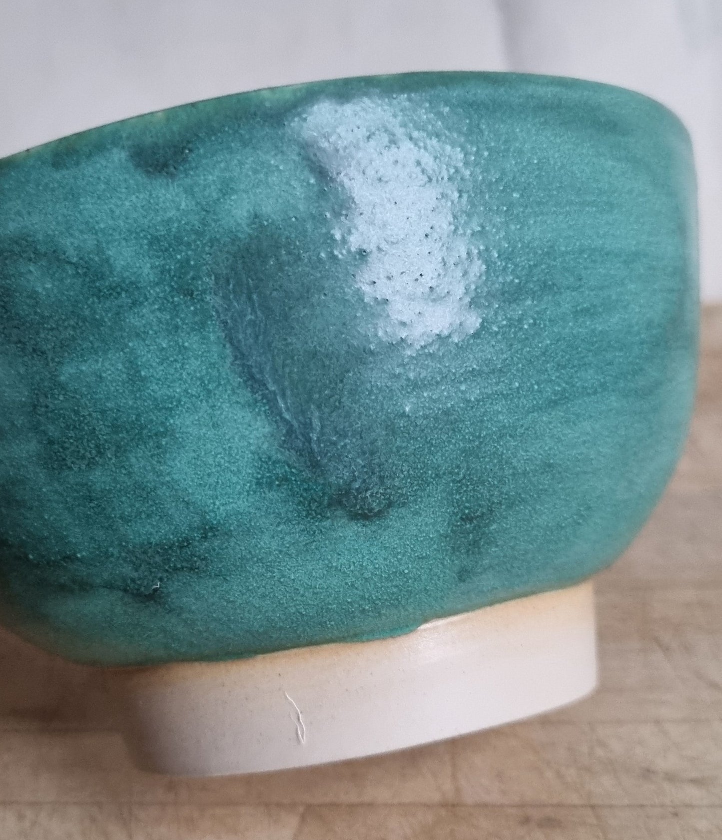 Green ceramic bowl on a wooden surface