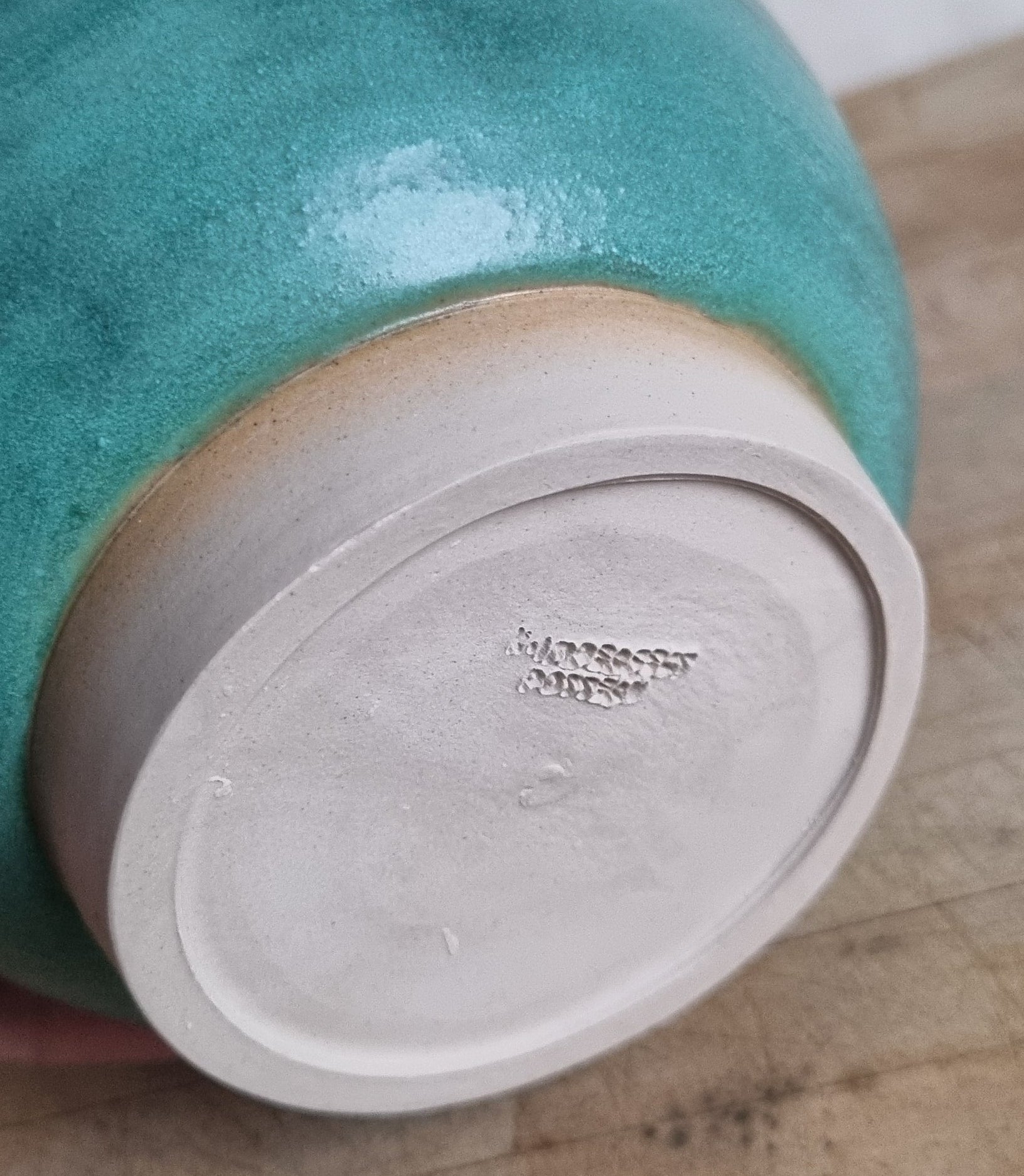 Turquoise ceramic bowl on a wooden surface