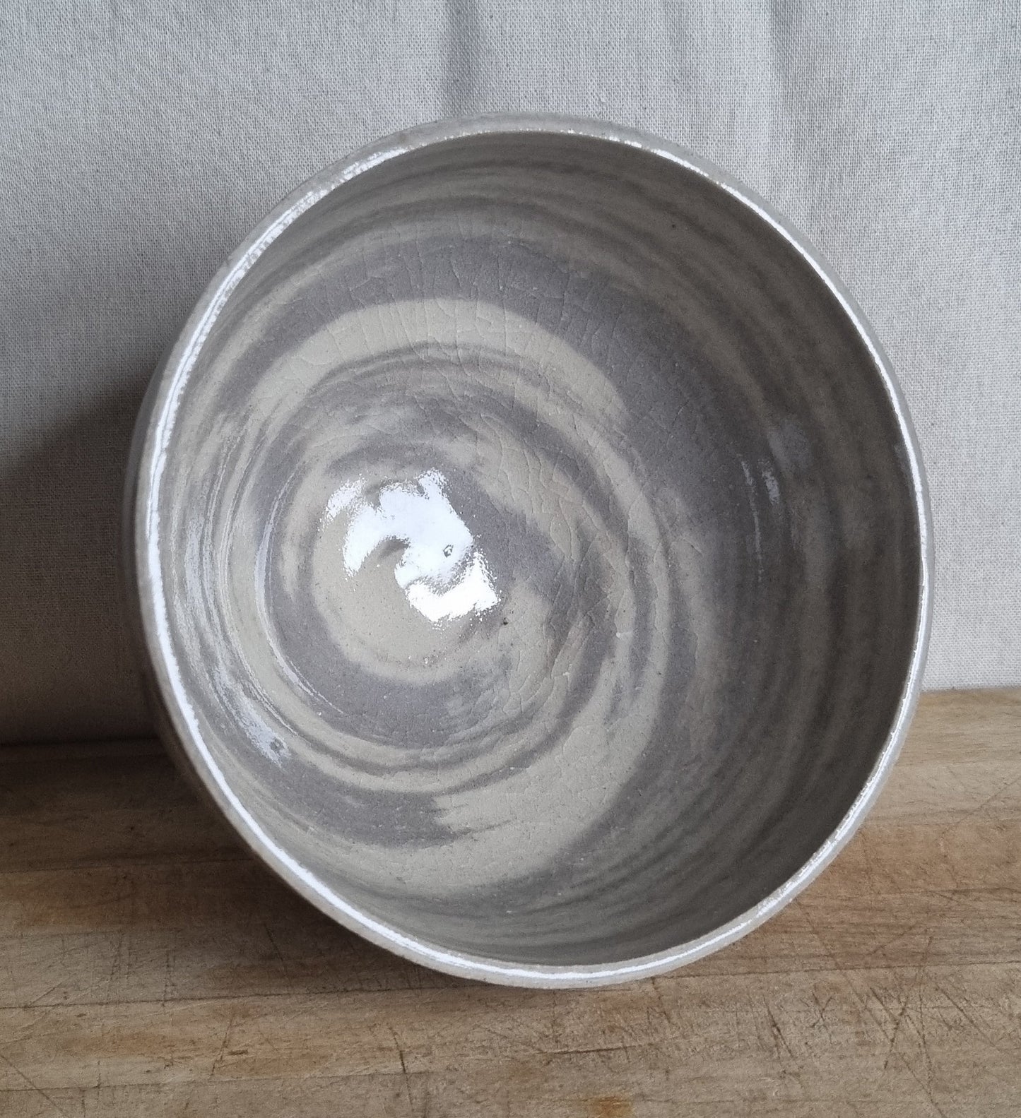 Ceramic bowl with swirling pattern on a wooden surface