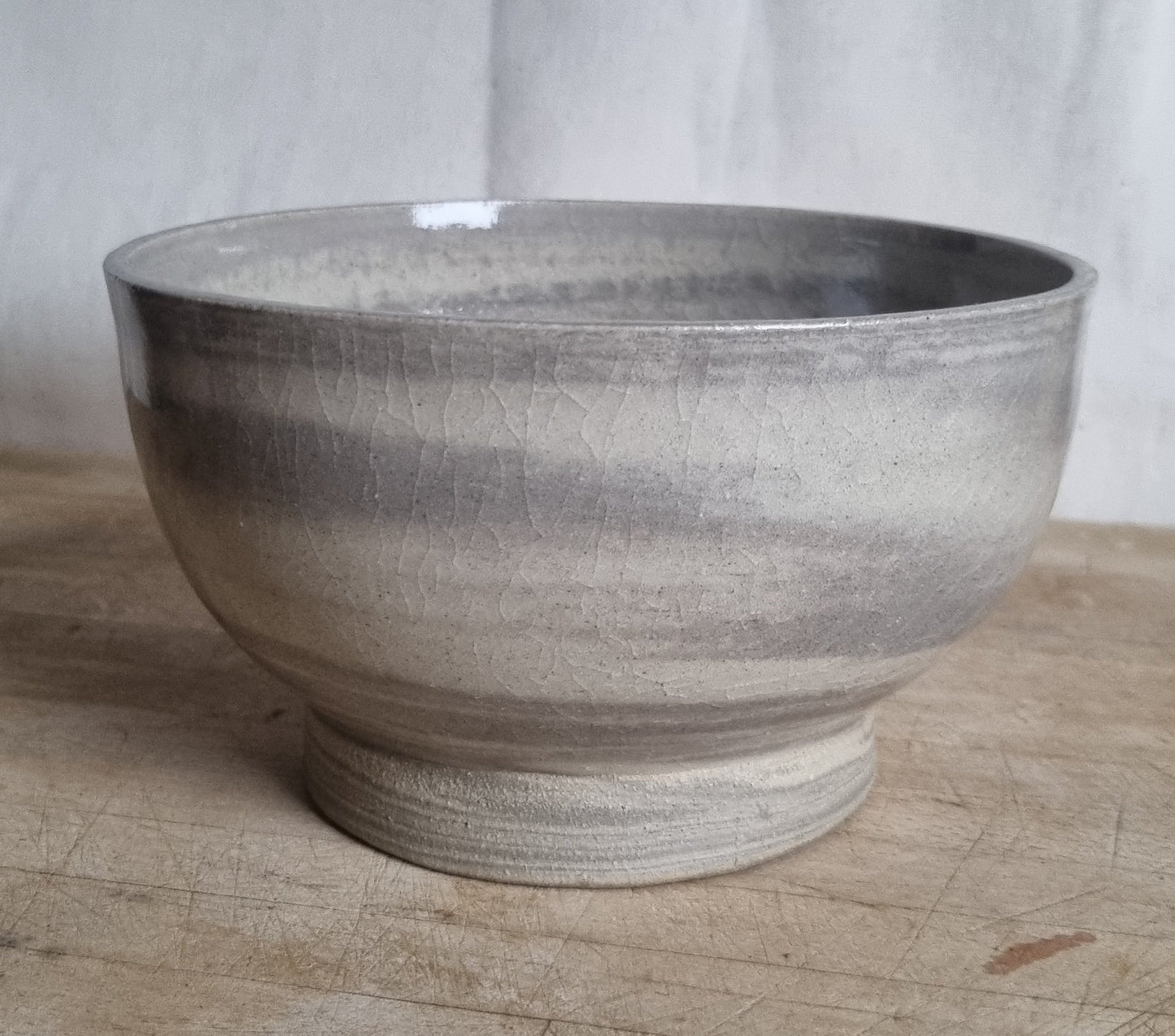 ceramic bowl with swirly pattern caused by mixing two clays together resting on wooden board