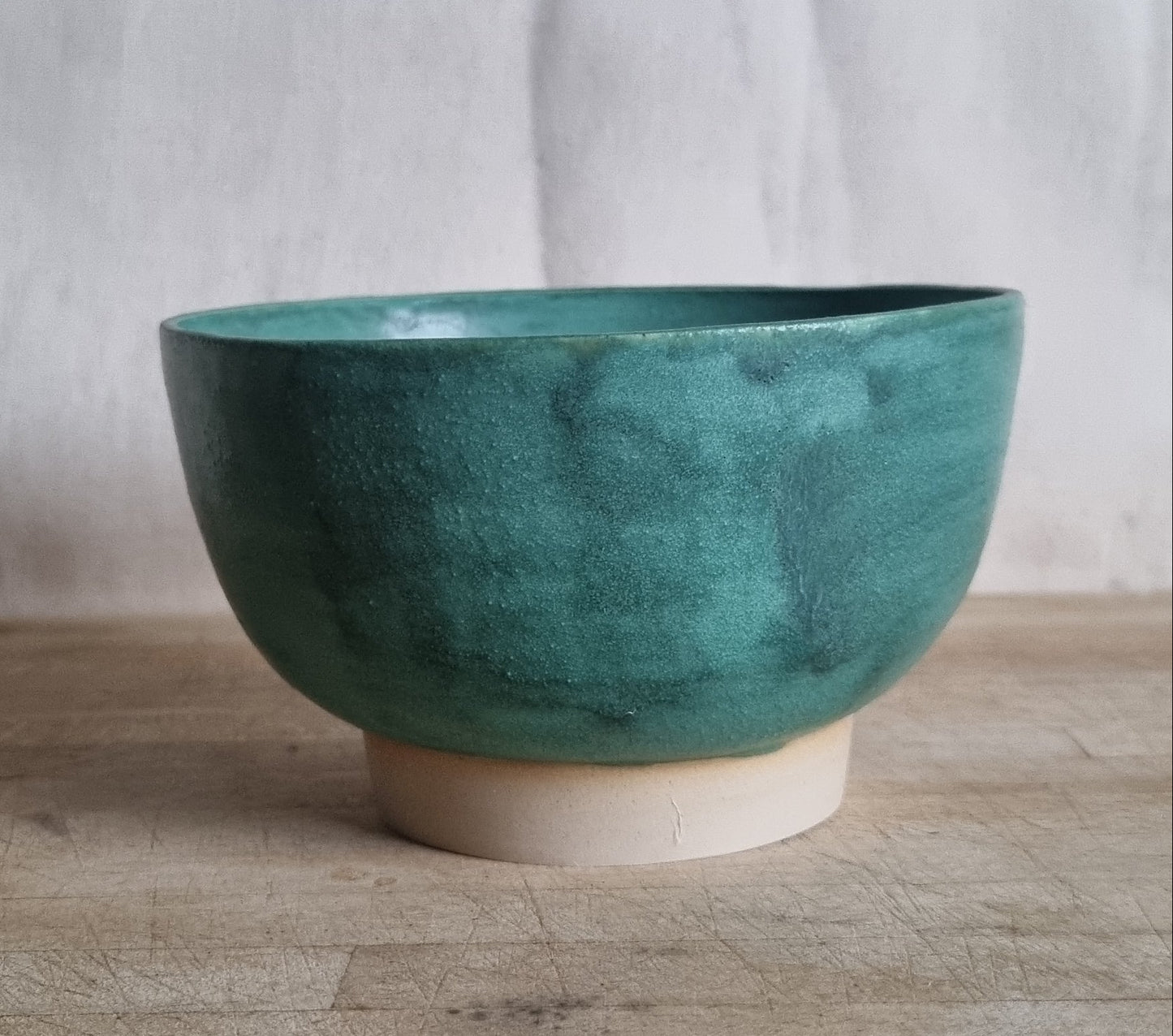 Green ceramic bowl on a wooden surface